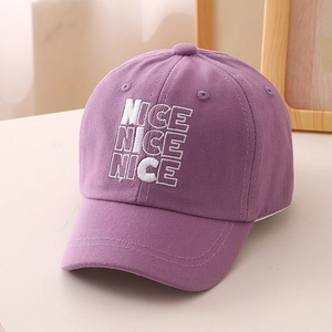 Detail of embroidered NICE letters on light purple cotton baseball cap for kids
