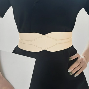 Detail of beige elastic waist belt with diamond stitching on a black dress coat