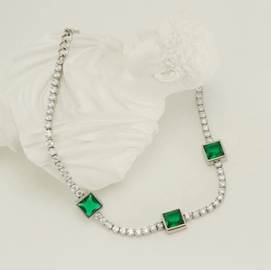 Detail view of silver titanium steel bracelet featuring square green zircon and crystals