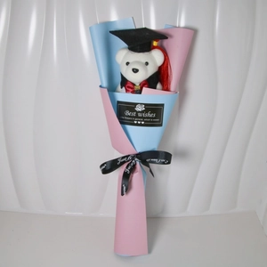 Detail of graduation plush bear bouquet with blue and pink paper and Best Wishes tag