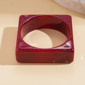 Detail of square wine red acrylic bangle with marble pattern and smooth resin finish