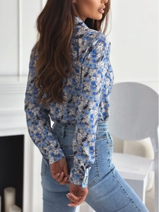 Side view of long-sleeve floral shirt with blue and white pattern and denim jeans