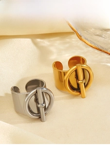 Macro view of gold and silver stainless steel toggle clasp rings on satin fabric