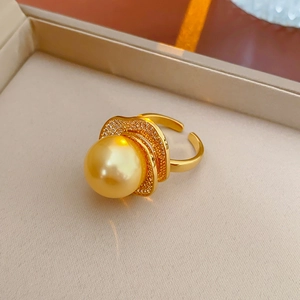 Close-up of a luxury gold ring with a large golden pearl and sparkling zircon accents