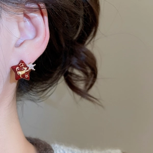 Macro shot of 18k gold plated star earring with red enamel and shimmering cubic zirconia