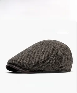 Detail view of khaki tweed flat cap with dark brown leather brim for autumn and winter