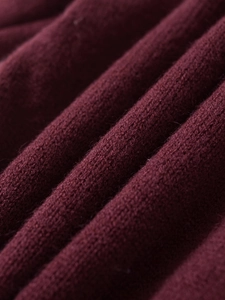 Detailed close-up of dark wine red knitted fabric with soft texture and woven patterns
