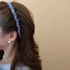 Blue knitted wave headband with mixed yarn texture and a high top silhouette for women
