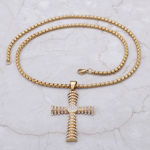 Hip hop style gold pendant necklace featuring a diamond-encrusted cross and pearl chain