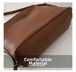 Detail shot of the brown litchi pattern leather bottom and durable stitching on tote bag