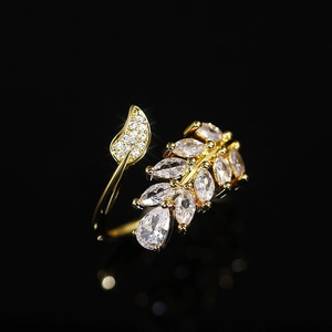 Macro detail of leaf-shaped ring with marquise-cut zircons on a dark background