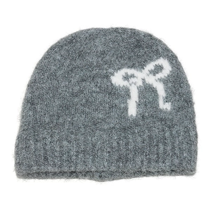 Detail of grey knitted wool beanie with white bow pattern showing soft mohair texture