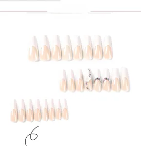 Detail of long coffin press-on nails with white French tips, 3D flowers and rhinestones
