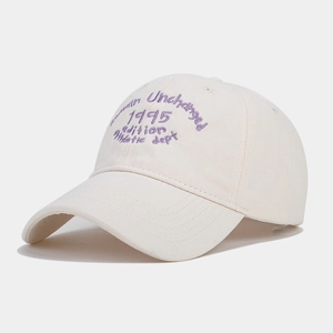 Detailed purple embroidery on off-white cotton baseball cap featuring vintage 1995 text
