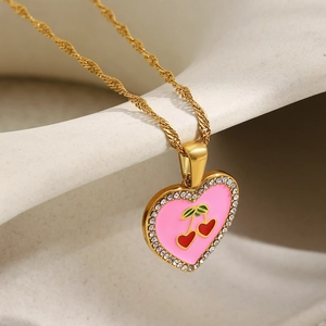 Close-up of heart pendant with pink enamel, cherry pattern and white zircon stones