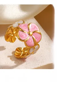 Close-up of pink enamel flower ring with gold finish and adjustable open band detail
