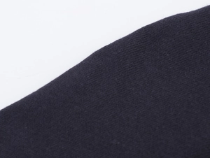 Close-up of deep blue knit fabric showing dense texture and high-quality fiber detail