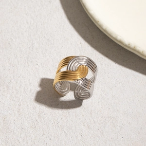Detail view of woven gold and silver wave lines on a stainless steel open ring