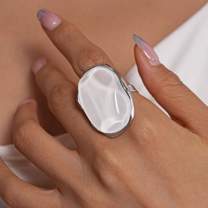 Macro detail of large irregular white resin ring with a silver-tone metal setting