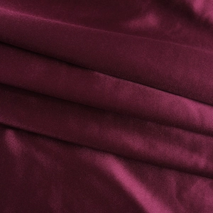 Vue macro détaillée du tissu en satin bordeaux avec une texture tricotée fine et un drapé élégant