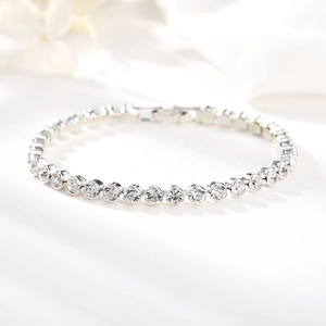 Klassisches silbernes Tennisarmband mit 4mm Zirkonia auf weißem Seidenhintergrund