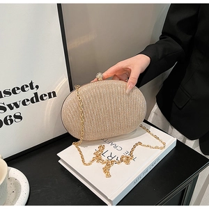Close-up of champagne gold glitter evening clutch with spherical diamond clasp and chain