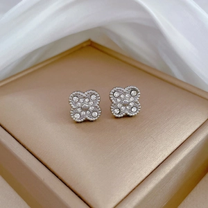 Detailed view of silver clover earrings with sparkling pavé crystals and beaded edges
