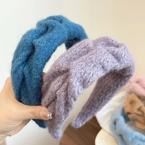 Detailed close-up of soft knitted wool headband texture in various pastel colors