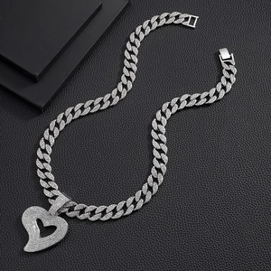 Macro shot of silver hip-hop Cuban chain necklace with large iced-out heart pendant