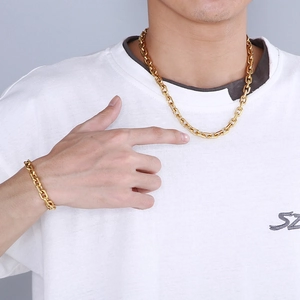 Detail of 18K gold-plated stainless steel cross chain necklace and bracelet on model