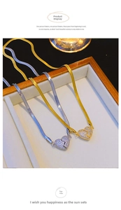 Close-up of gold and silver heart necklaces with crystals on a jewelry tray