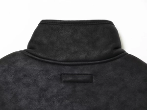 Close-up of black faux suede jacket collar showing fine texture and premium stitching