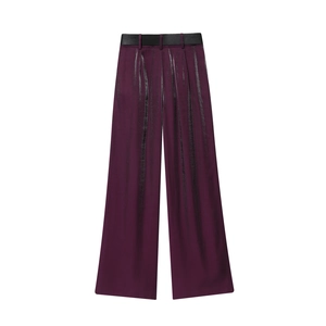 Detailansicht der lila Satin-Hose mit weitem Bein, elegantem schwarzem Gürtel und Metallglanz