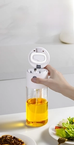 Détail du pulvérisateur d'huile en verre avec couvercle automatique et poignée de cuisine