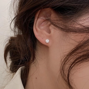 Gros plan d'un clou d'oreille en argent S925 avec zircon à quatre griffes porté par un mannequin