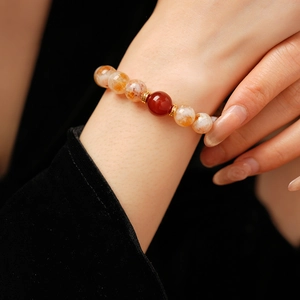 Gros plan de perles de citrine jaune et agate rouge sur le poignet d'une femme