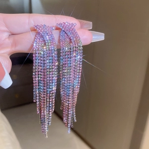 Macro shot of long fringe earrings with multi-color rhinestones and silver metal finish