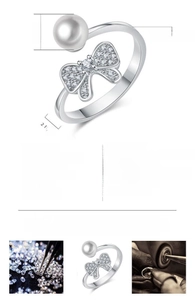 Detail view of adjustable copper ring with sparkling bow and white pearl accent.