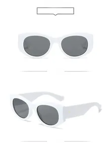 Detail of white thick oval frame sunglasses with gold dot accents and dark lenses