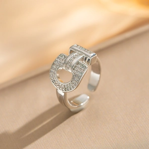 Close-up of silver horseshoe ring with pavé crystals on a silk background