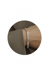 Close-up of gold plated tennis bracelet with rectangular zircon stones on a model wrist