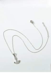 Detail view of anchor pendant necklace in titanium steel with shimmering cubic zirconia