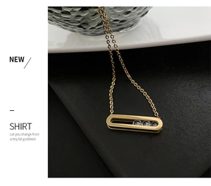 Close-up of a 18K gold plated necklace with three sliding zircons in a rectangular frame