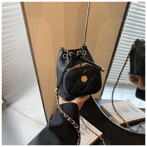 Detail of camellia bucket bag with gold chain strap and quilted faux leather texture