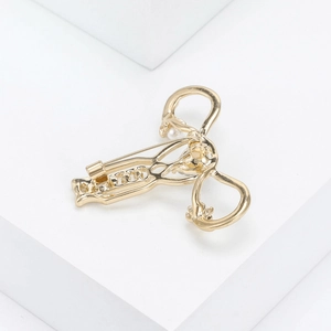 Detail of gold uterus brooch with intricate crystal rhinestones and pearl accents