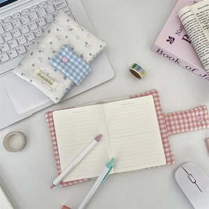 Detail of floral and plaid fabric journal covers with lined inner pages on a desk