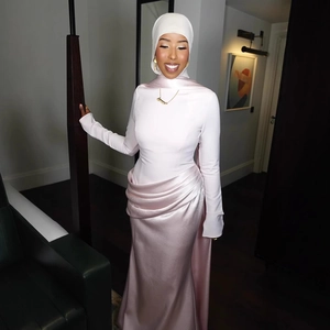 Close-up of light pink satin evening gown featuring waist pleats and matching hijab