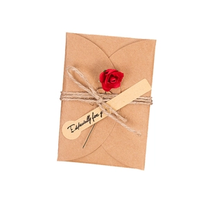 Biglietto d'auguri vintage in carta kraft con rosa rossa essiccata e cartellino