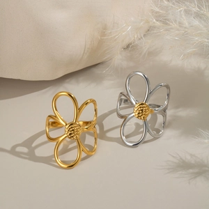 Modischer hohler Blumenring in Gold und Silber auf einem natürlichen Steinuntergrund