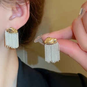 Golden and silver tassel earrings with hammer textured metal design on ear lobe